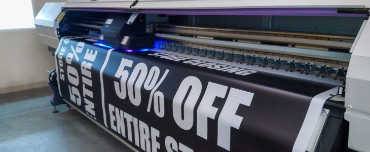Large-format printer running a printed job at the Graphink print shop in Doral, Miami